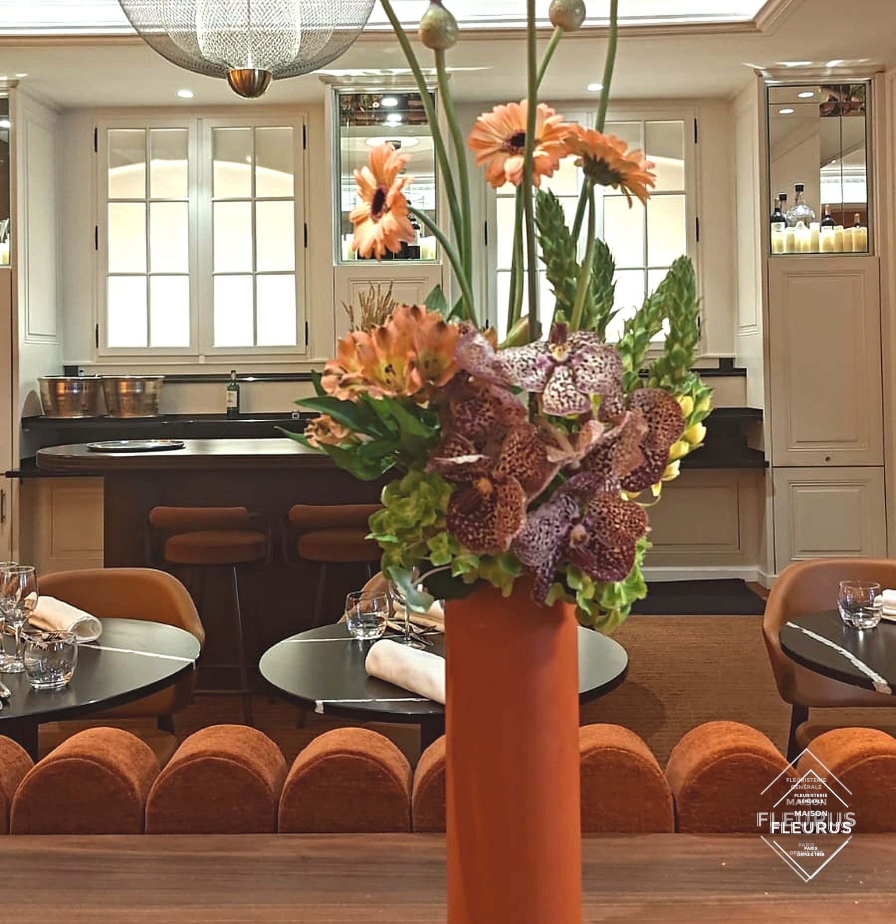 Bouquet de Présentation Maison Fleurus, vase orange, salle de restaurant